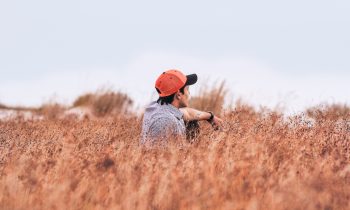 man sitting in a brown field